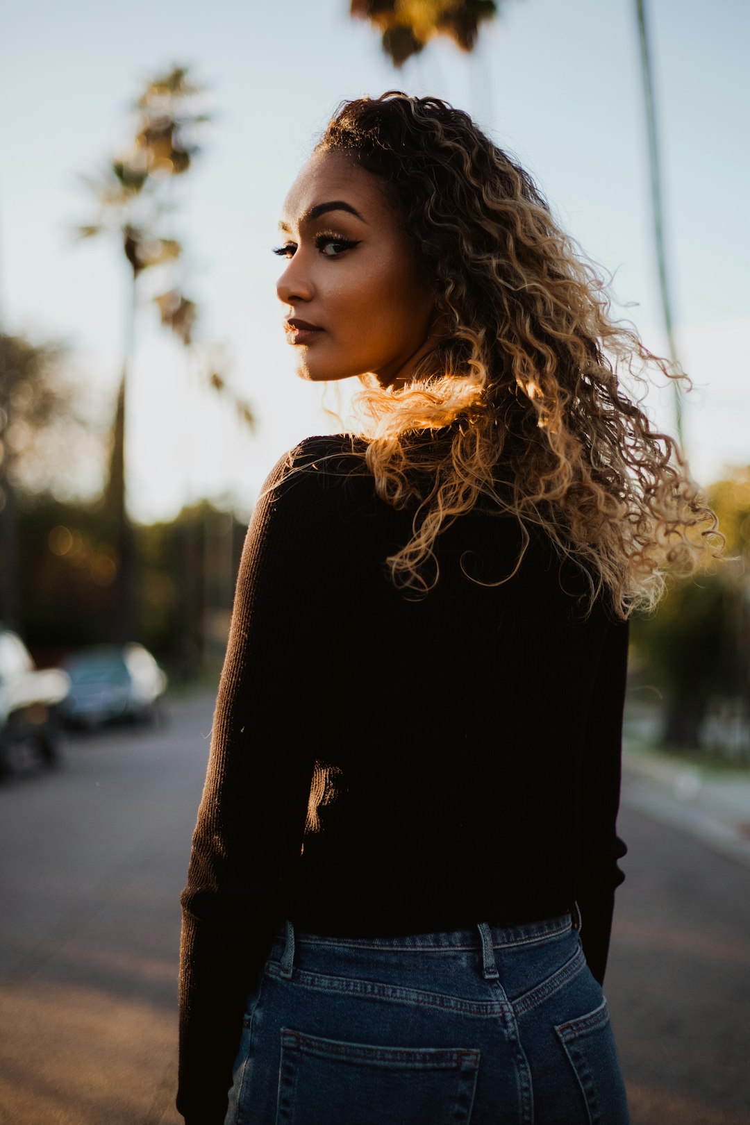 woman in brown sweater and blue denim bottoms