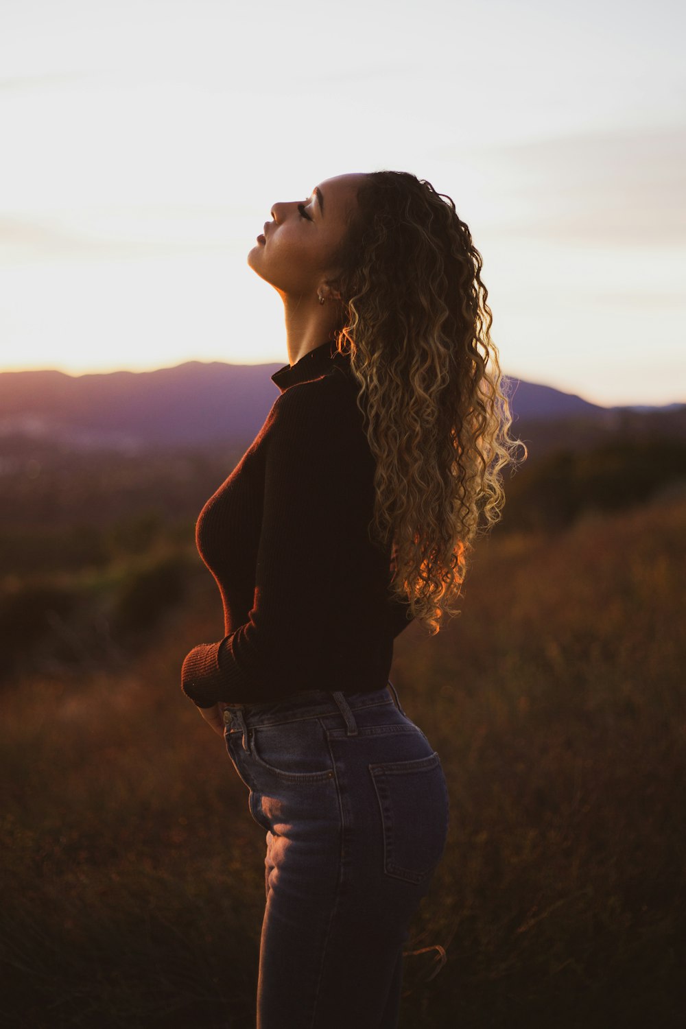 woman standing near outdoor while rising her head during daytime