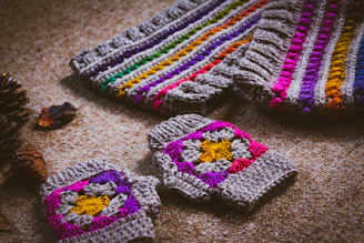 gray, orange, and purple crochet gloves