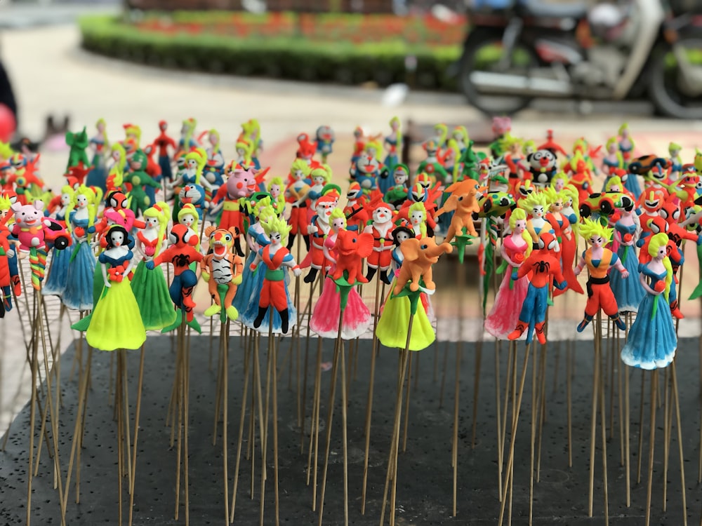 assorted figures on sticks displayed on black surface