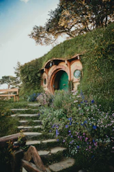 Sendero rodeado de naturaleza y en medio una casa de hobbit en Hobbiton Nueva Zelanda  