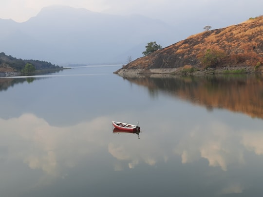 red and white boat in middle of body of water in Malampuzha India