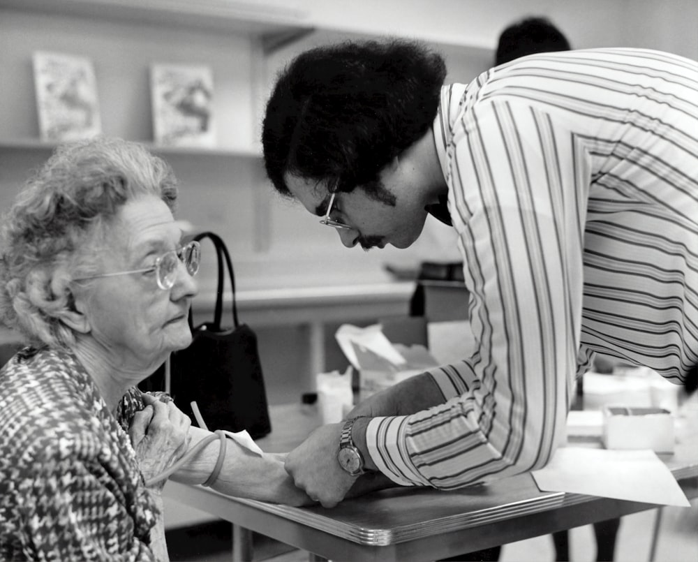 a man helping a woman with a piece of paper