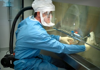 a man in a protective suit and mask working on a machine