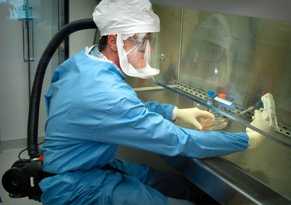 Un hombre con un traje protector y una máscara trabajando en una máquina