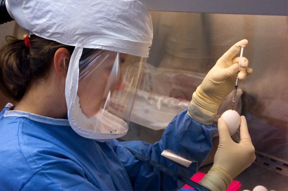 a woman in a lab coat and protective gear
