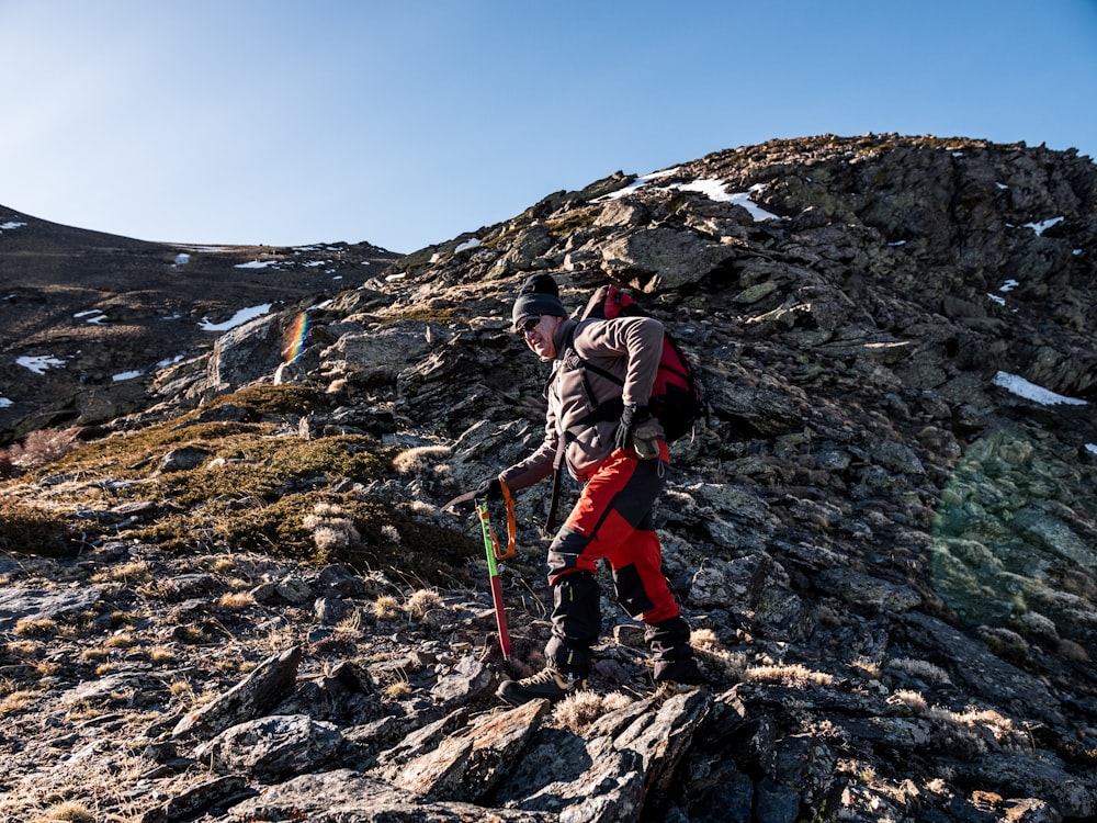 man climbing on rock mountain at daytime