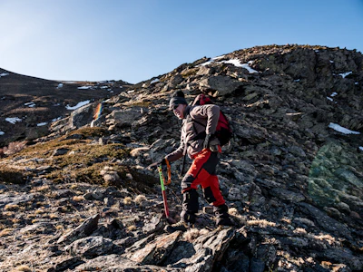 man climbing on rock mountain at daytime