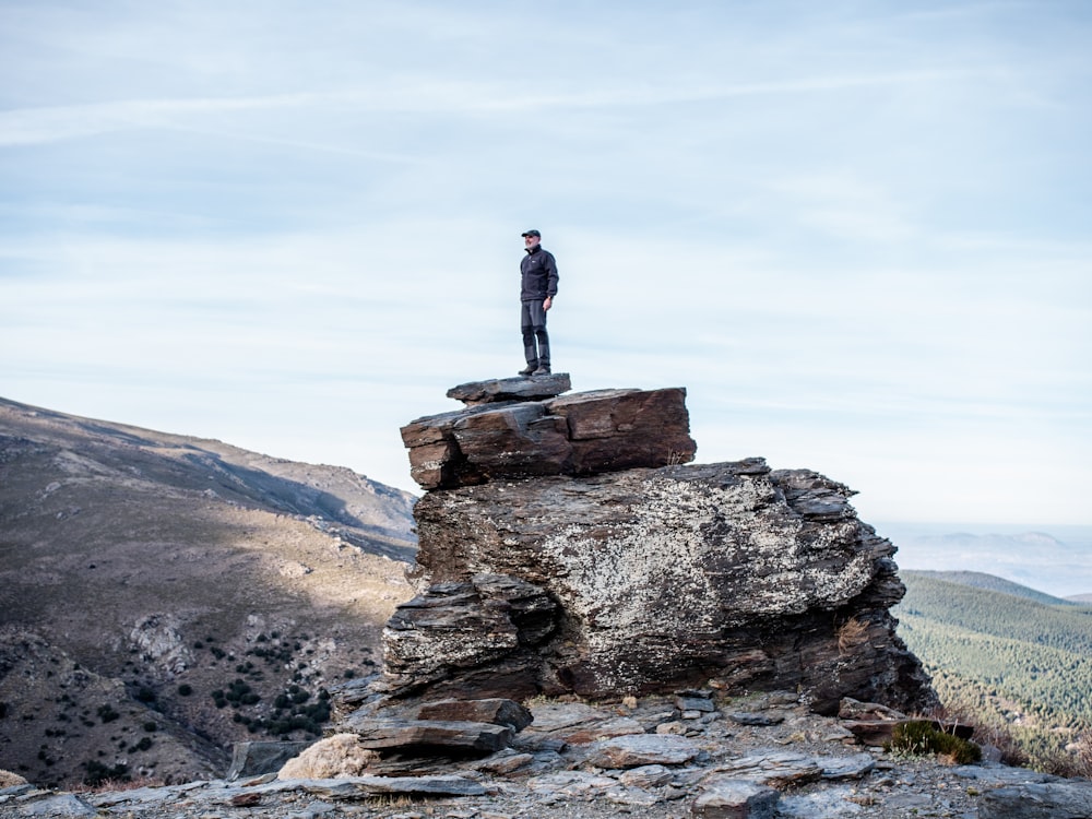 man standing on cliff during daytime