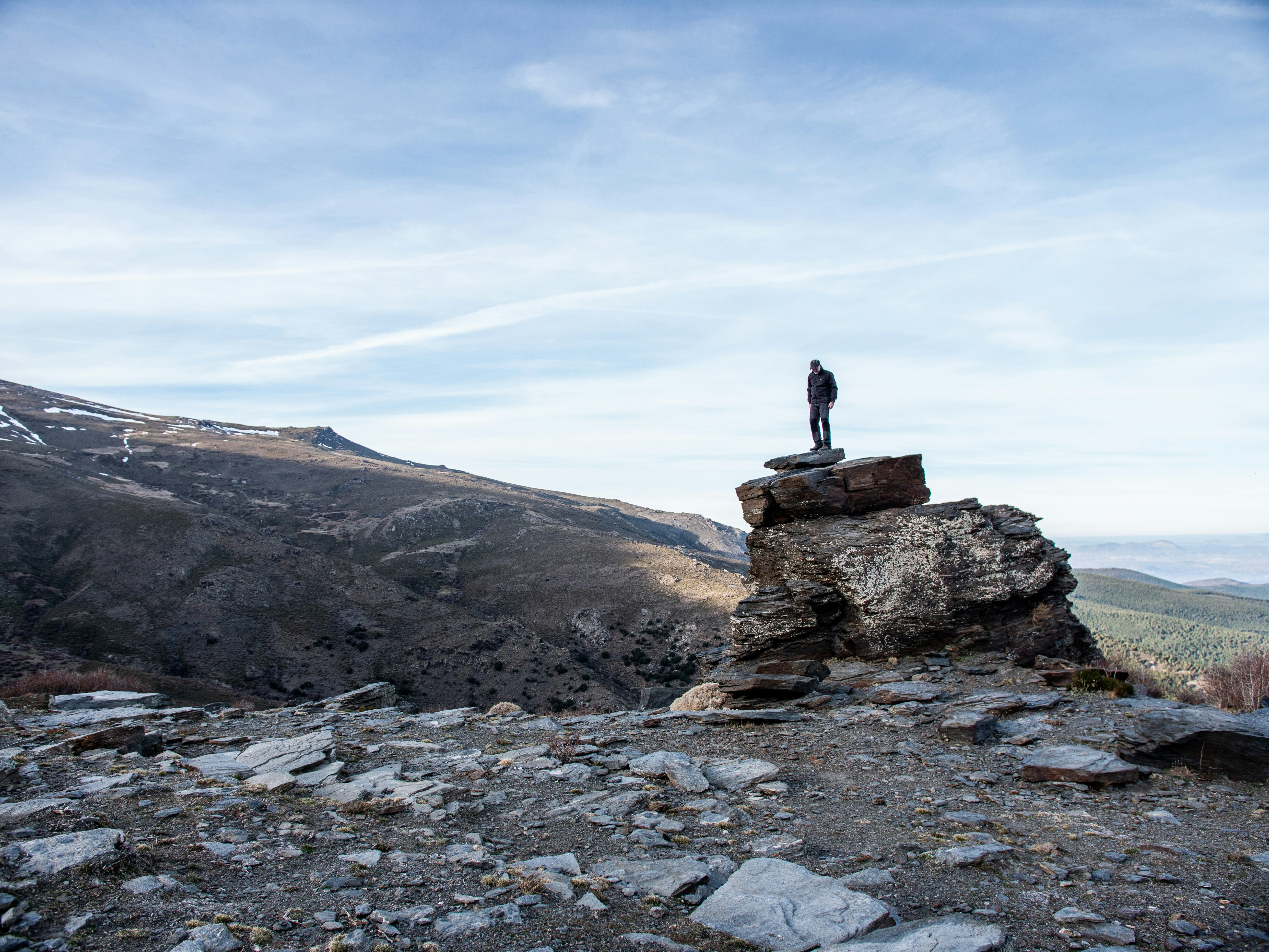 L'uomo si leva in piedi sull'affioramento durante il giorno