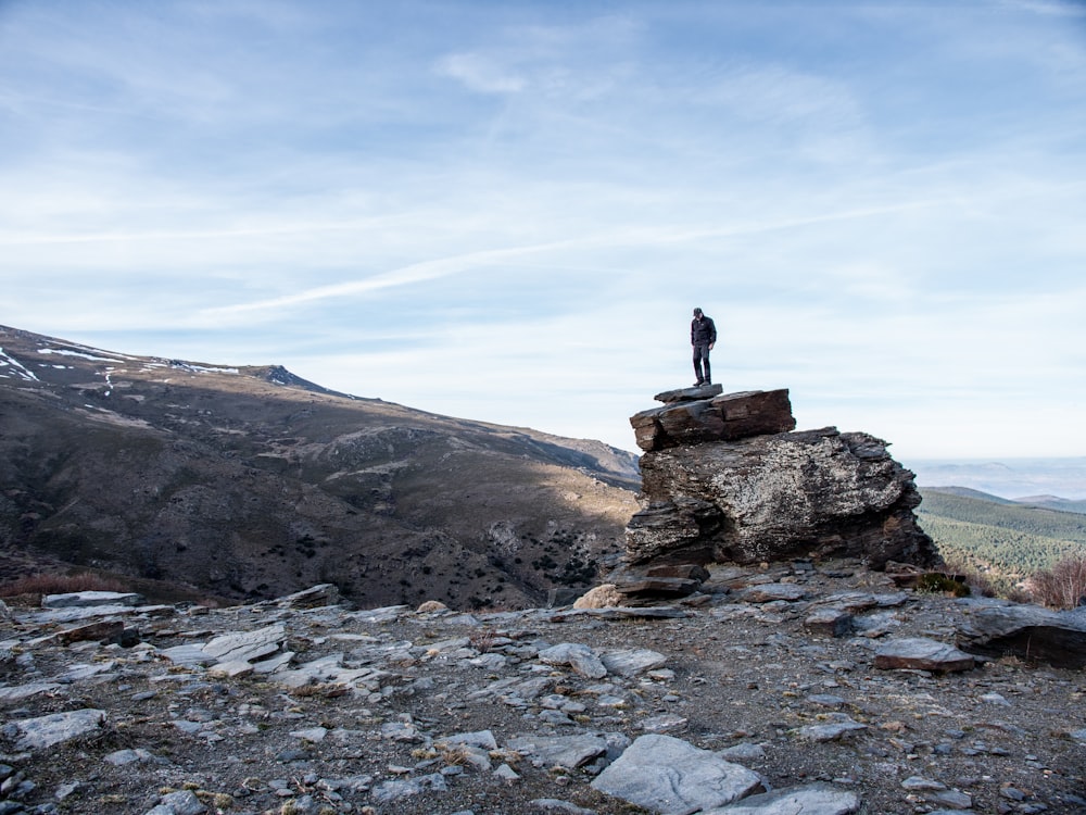 man stands on outcrop during daytime