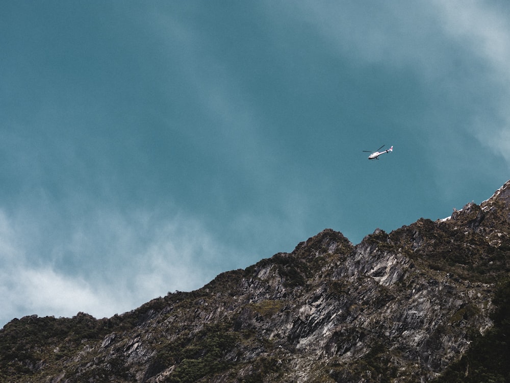 helicopter in mid air over mountain