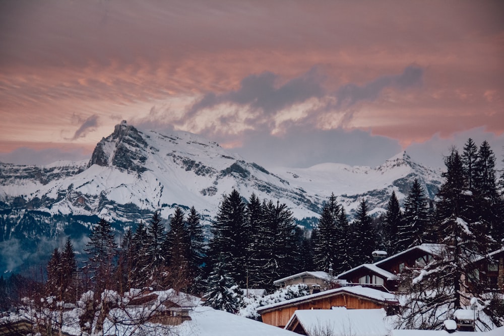 snow capped rocky mountain under cloudy sky during golden hour