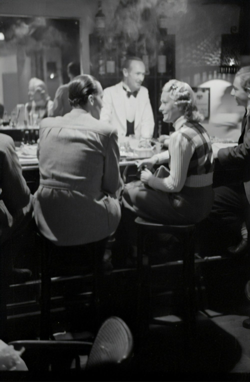 grayscale photography of unknown persons sitting indoors