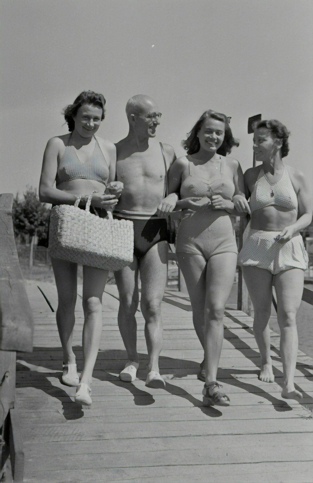 greyscale photography of three smiling woman and man