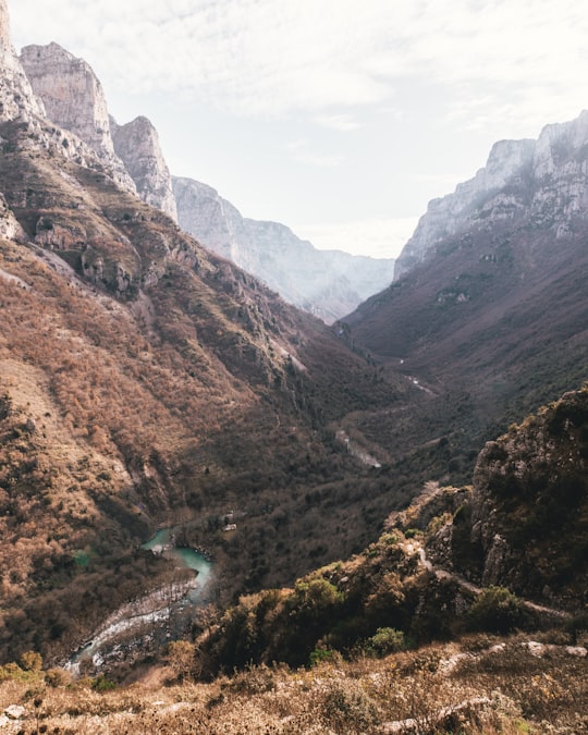 river between mountains under white sky in Vikos National Park Greece