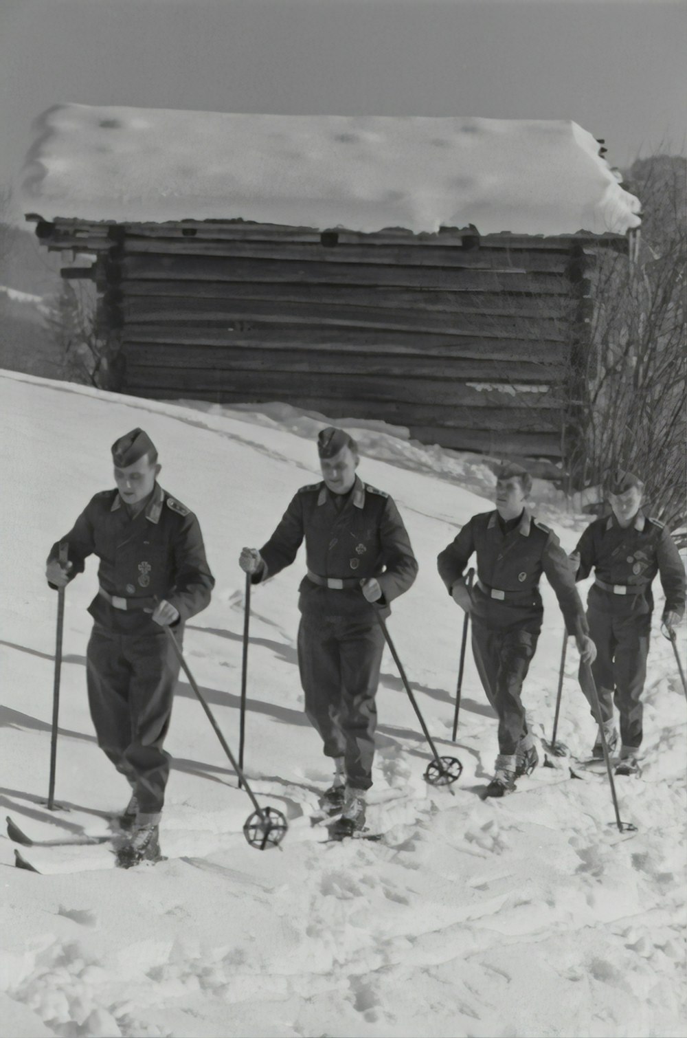 grayscale photography of four men walking on snow