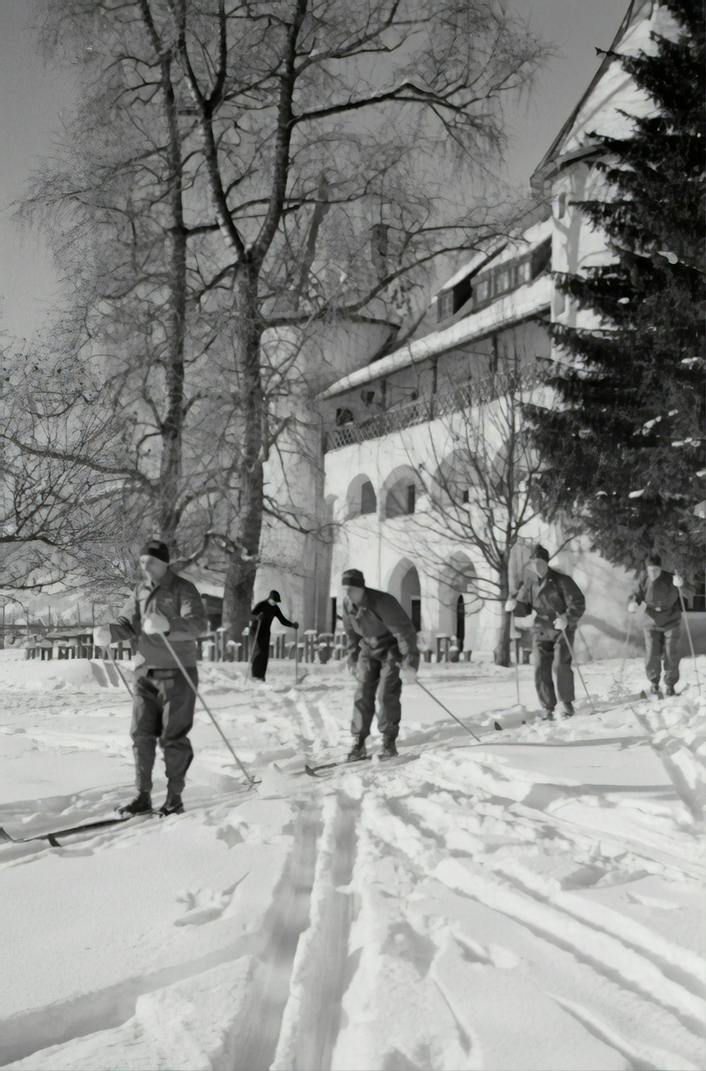 Fotografía en escala de grises Personas haciendo cielos nevados durante el día