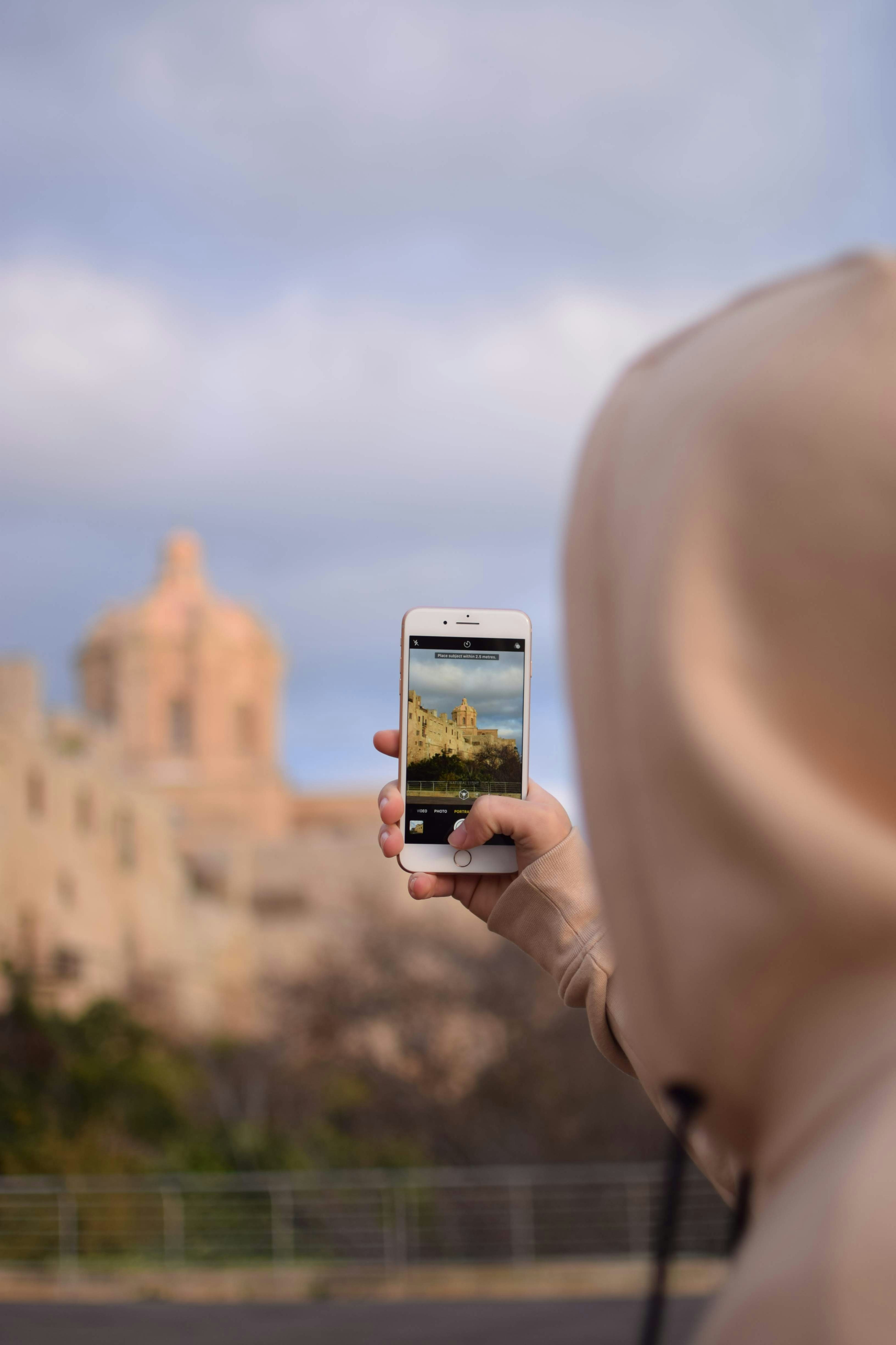 person taking photo of building during daytime