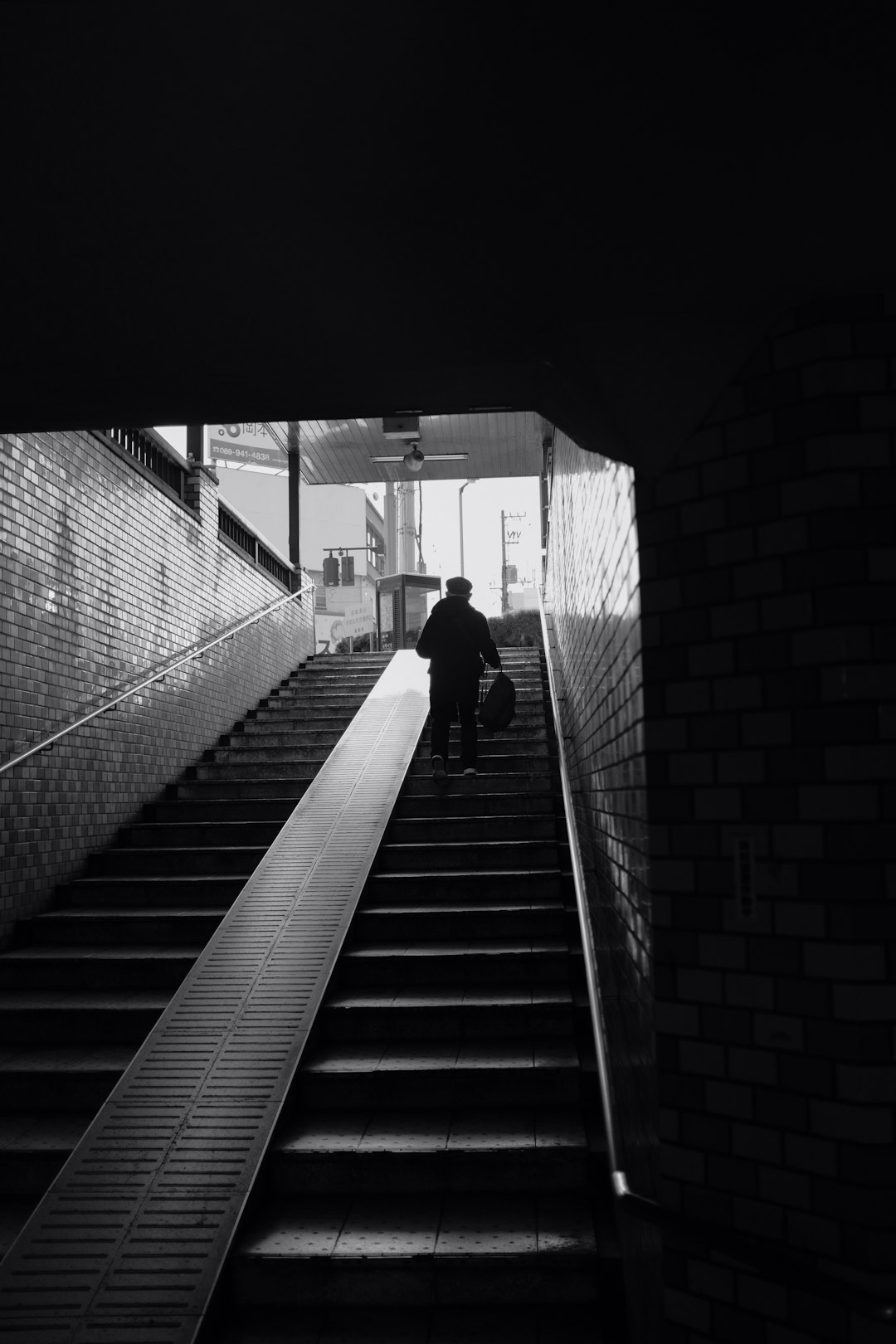 greyscale photography of person on stairs