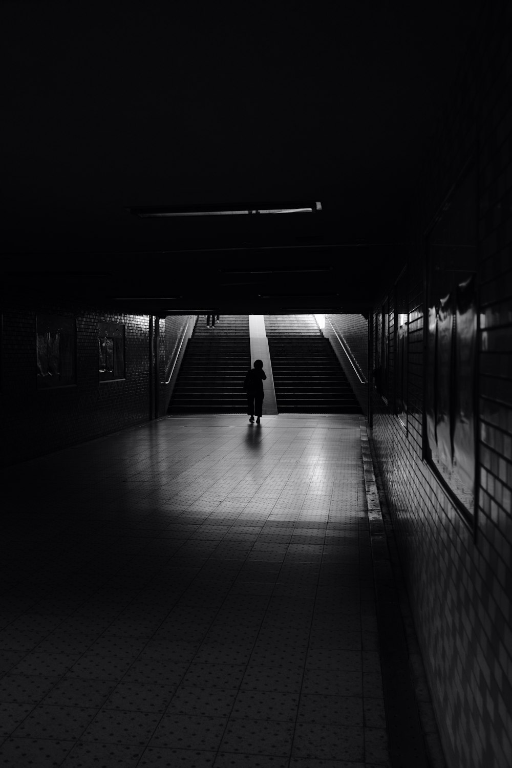 a person standing alone in a dark hallway