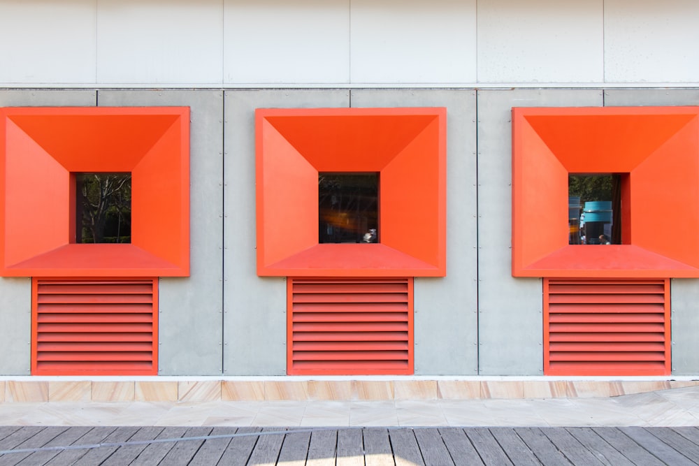 a red building with three windows and shutters