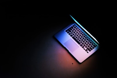 silver macbook air on black table