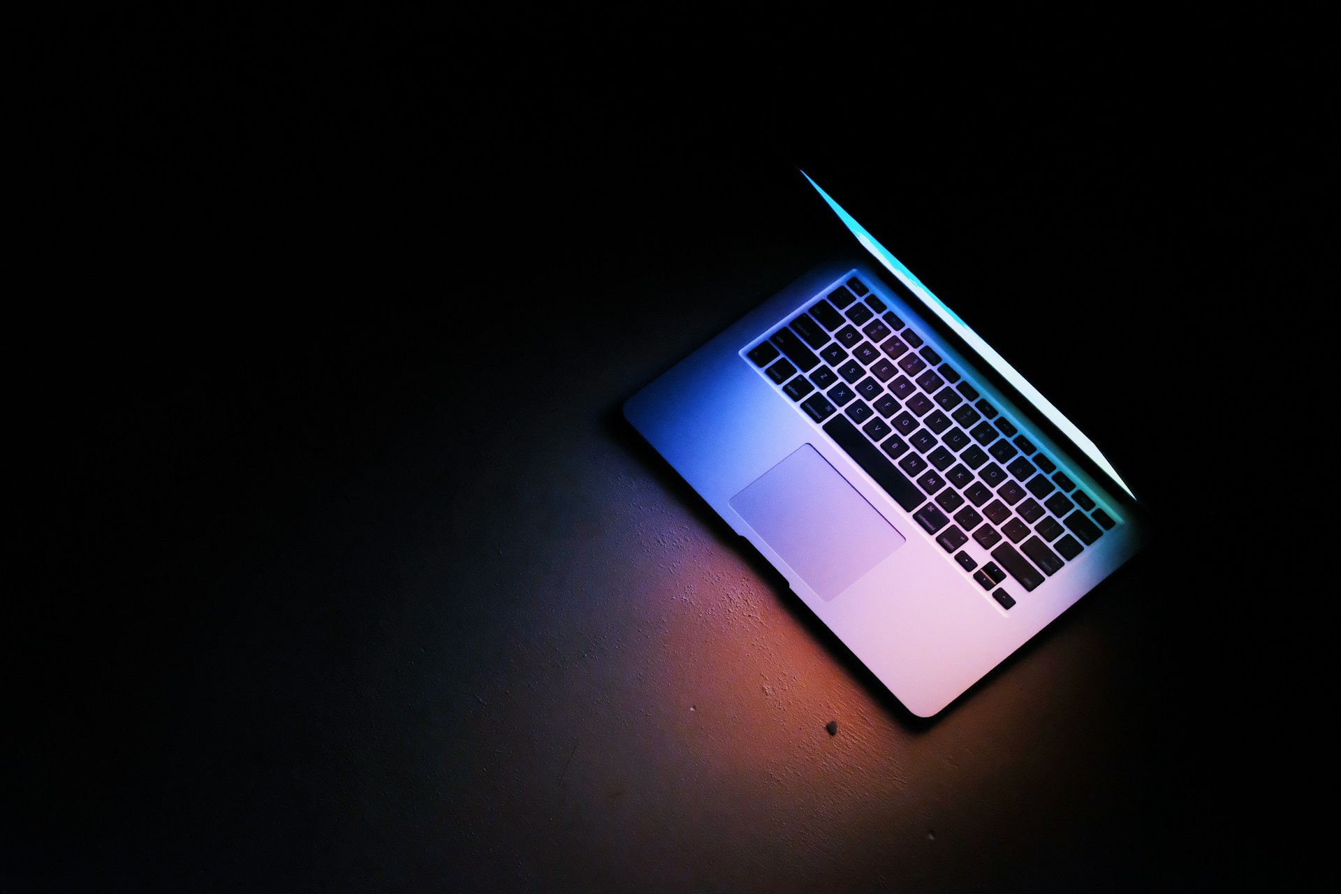 silver macbook air on black table