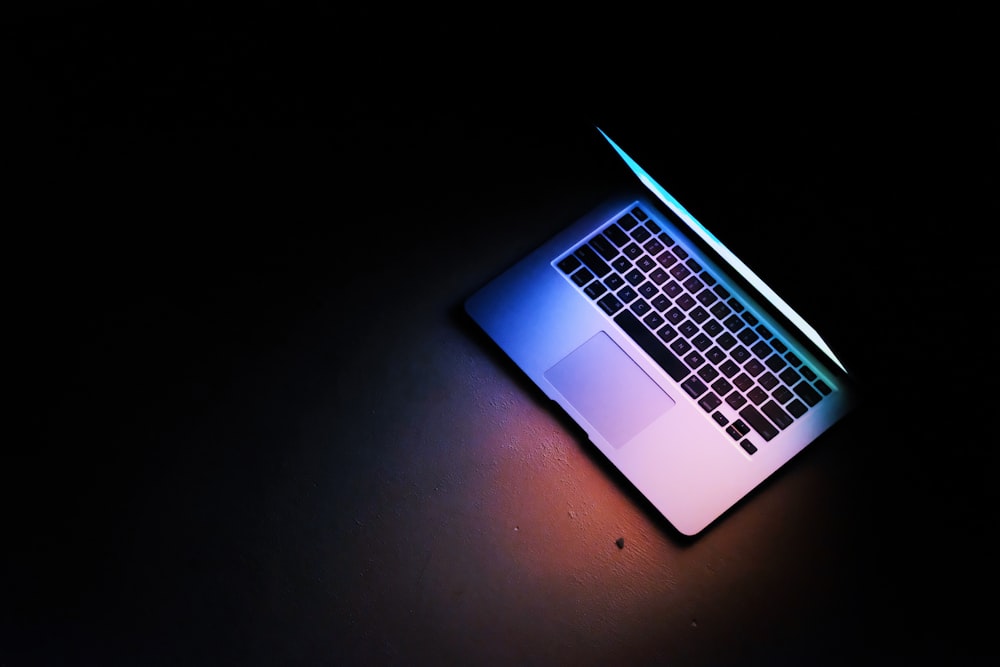 silver macbook air on black table