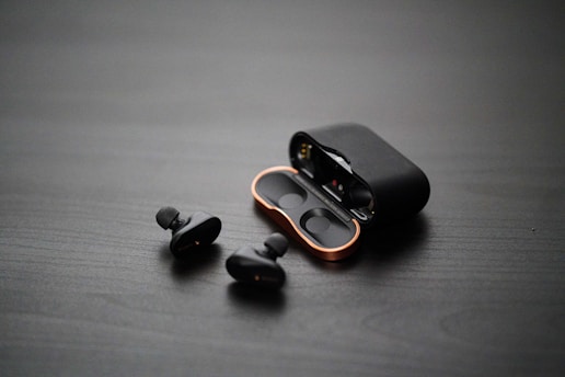 A sleek pair of advanced AI-powered earbuds on a modern surface.