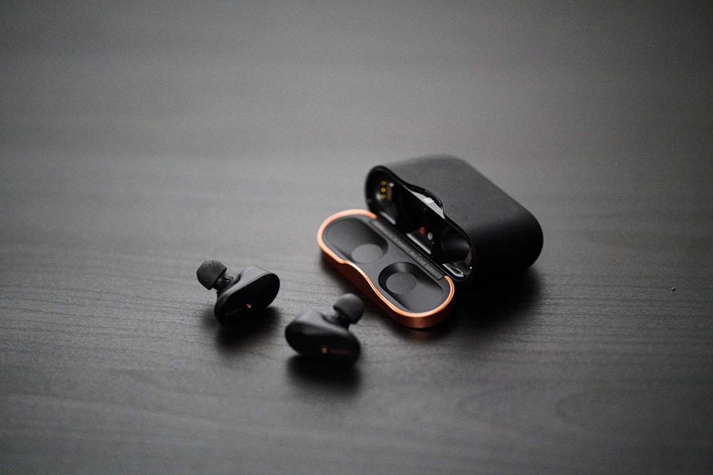 black wireless earphones on surfae