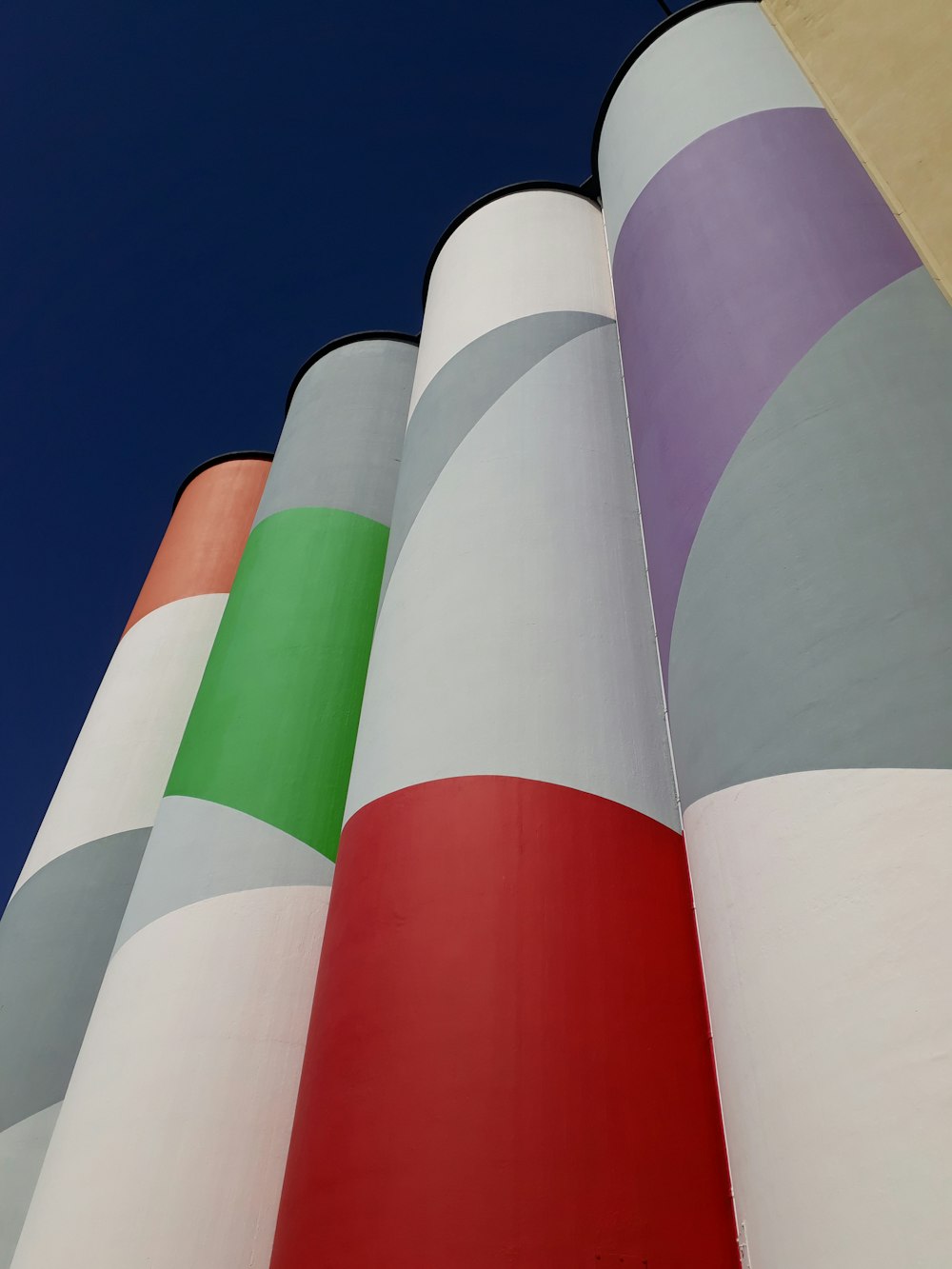 a tall multicolored building with a blue sky in the background
