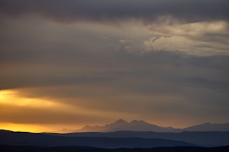 Expansive sea of clouds drifting over high mountain peaks at sunset