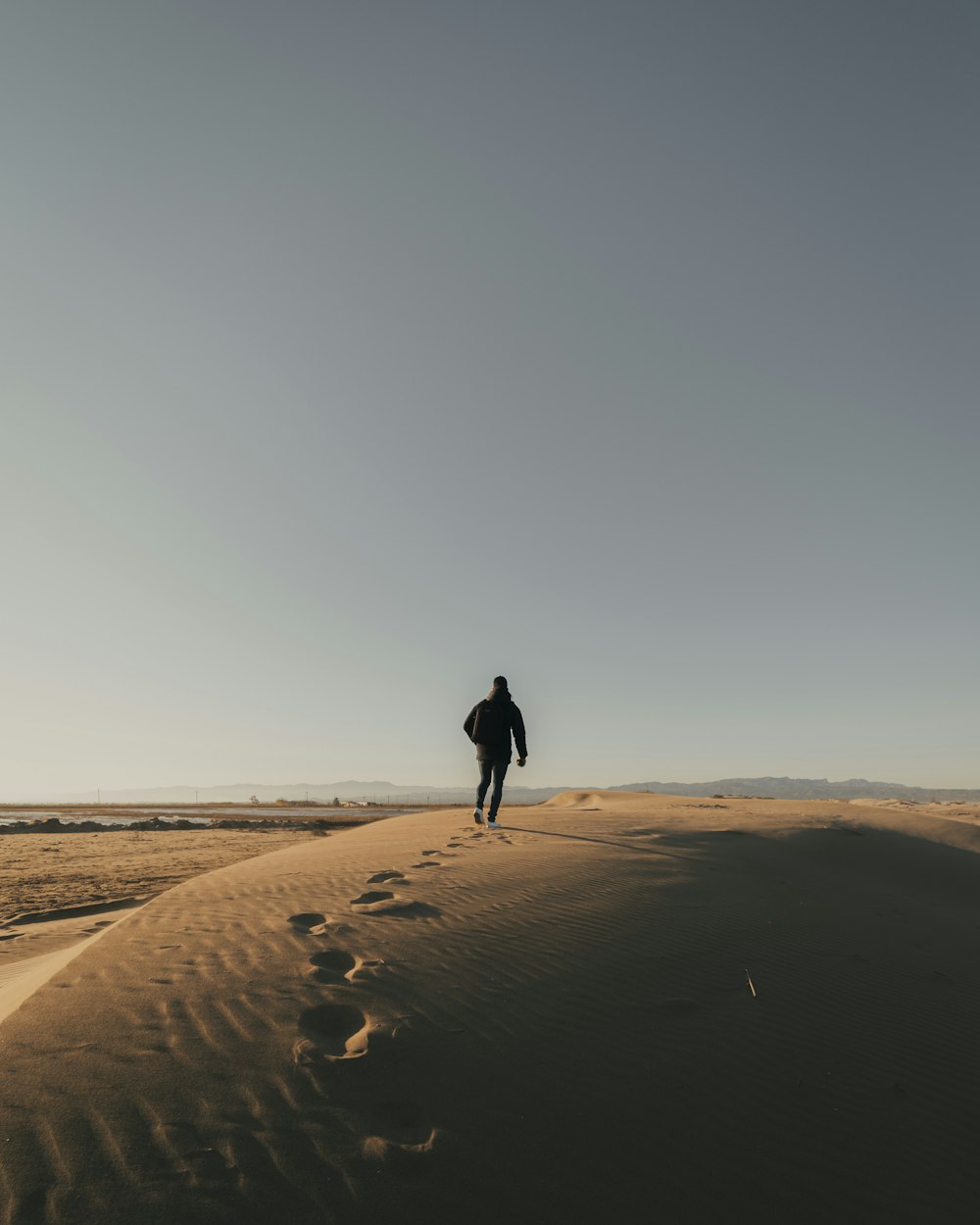 Mann geht auf dem Sandfeld Foto