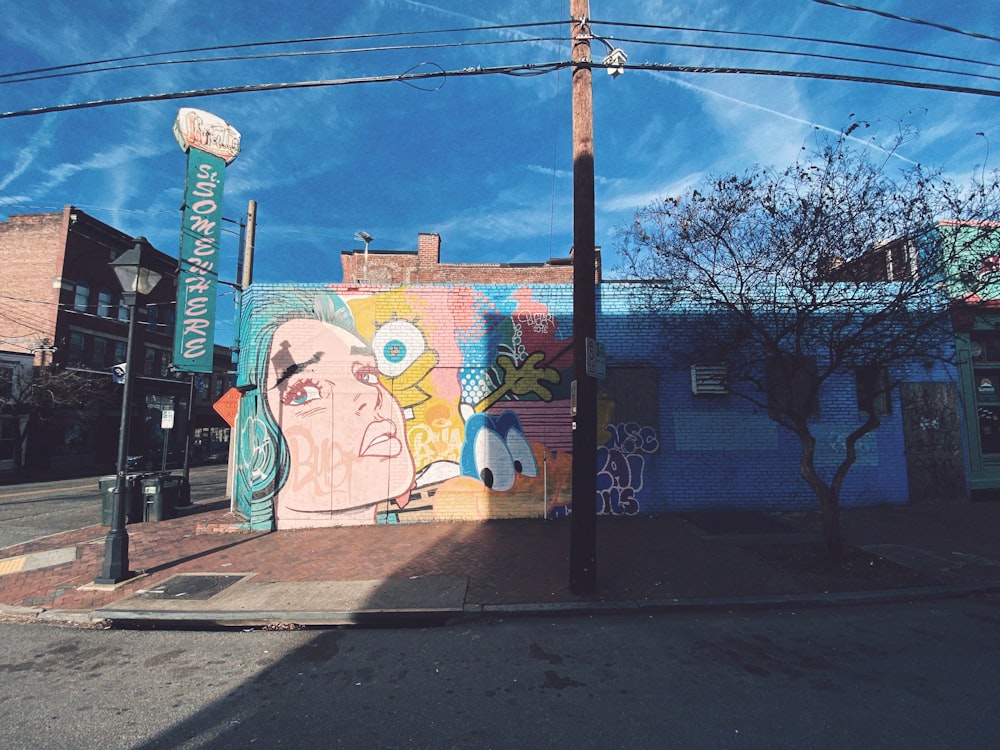 concrete building with multicolored graffiti art under blue and white sky