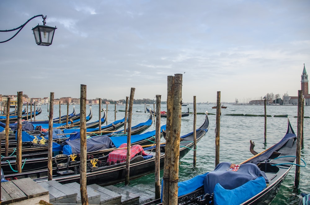 boats on body of water near wooden dock under gray and white sky