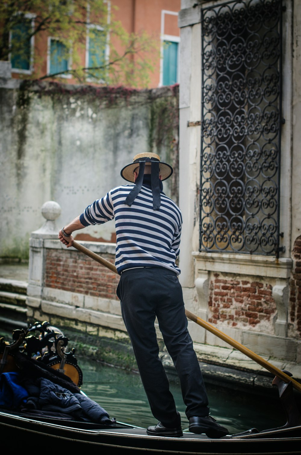 man in striped top rowing a boat during daytime