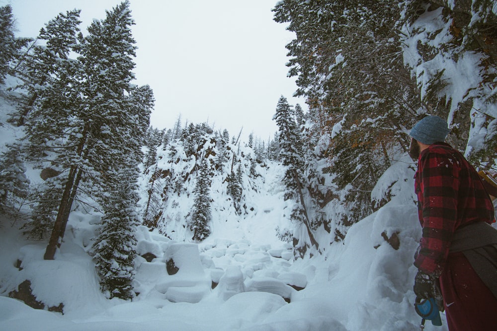 man standing in front of snow-covered trees