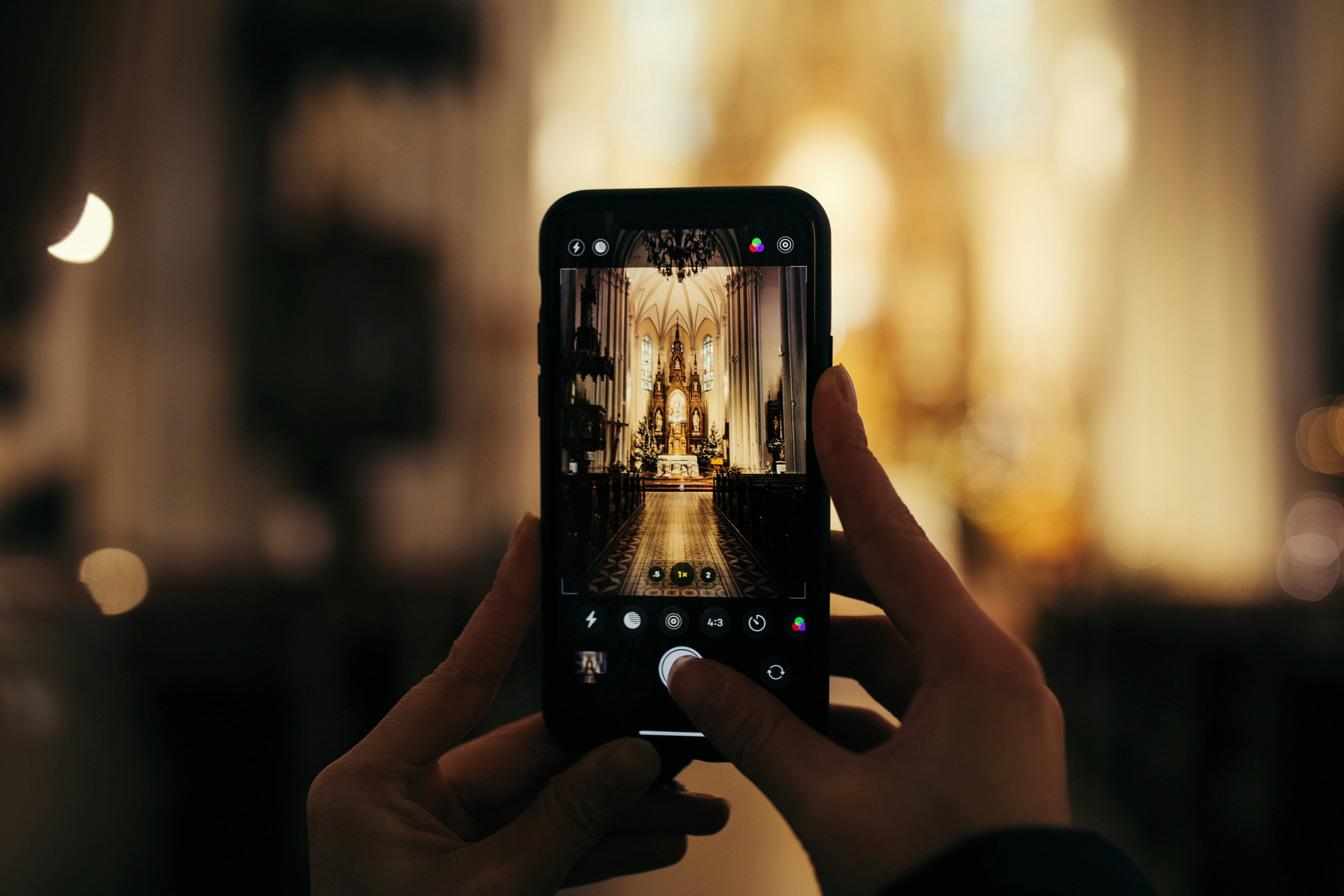 Person Holding Black Smartphone Taking Photo Of Statue