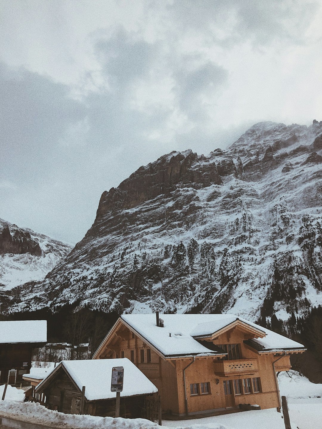 house near mountain covered with snow during daytime