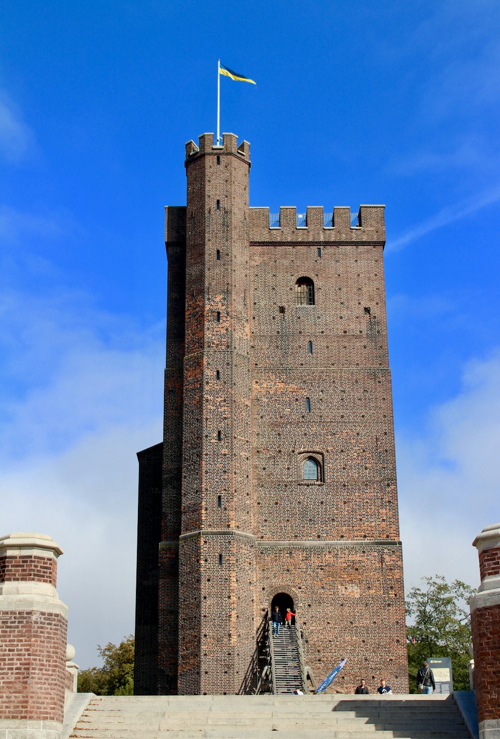 Gente cerca de Brown Historic Castle bajo el cielo azul y blanco