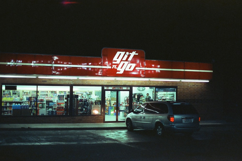 silver minivan parked beside Git N' Go store during night