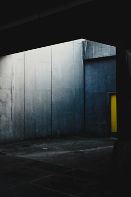 Monochromatic architectural studio interior with sleek concrete walls and minimalist furniture emphasizing contrast.