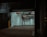 A dimly lit parking garage entrance with a sign indicating '24 hr. Parking'. The walls are tiled in white, and several overhead signs provide instructions like 'pull ahead' and 'drive slowly'. The atmosphere is somewhat shadowy, with industrial elements such as pipes visible.