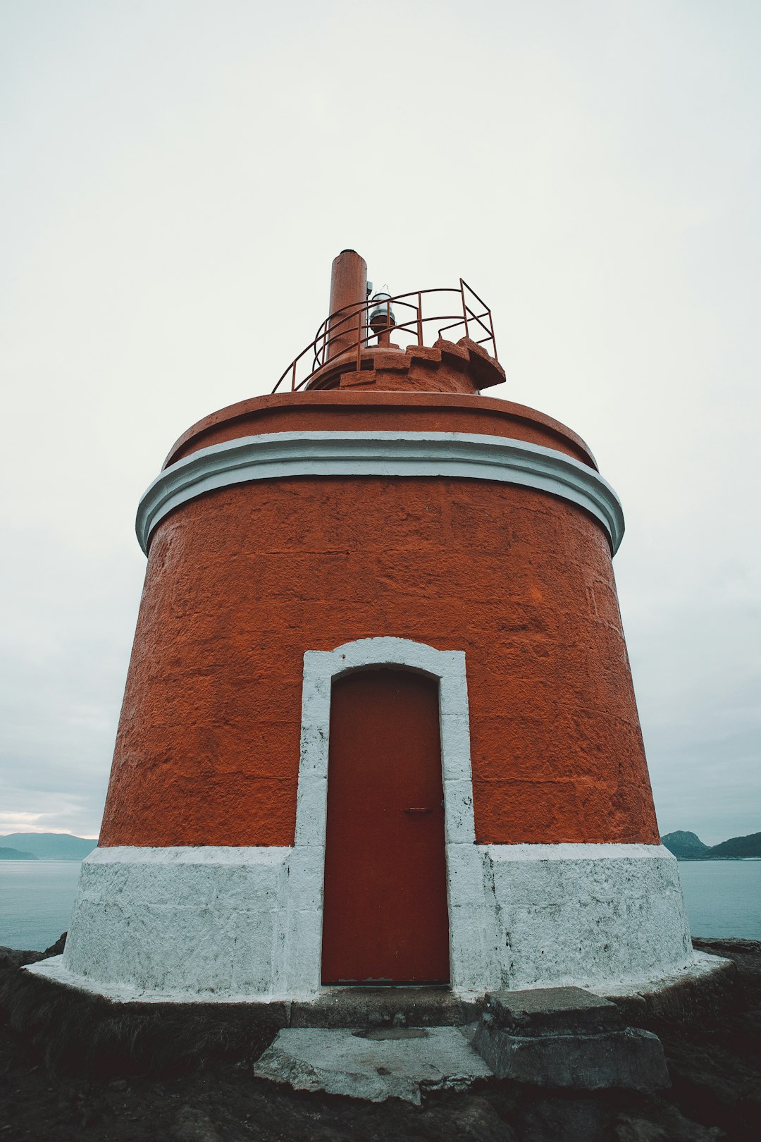white and brown lighthouse under gray sky