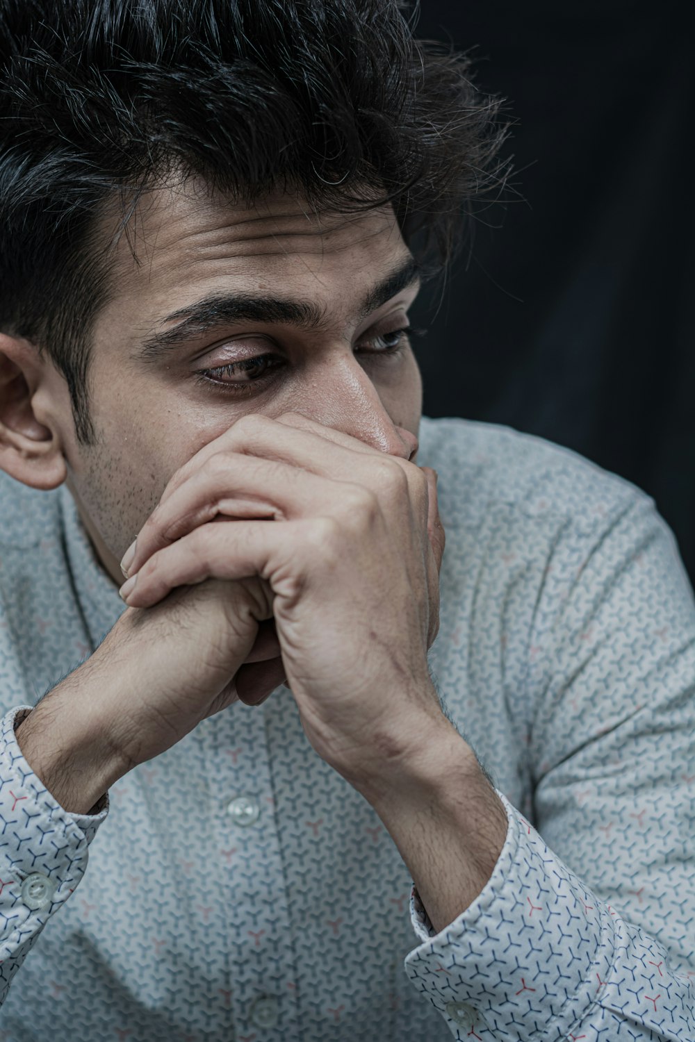 portrait photography of man wearing white and gray collared button-up long-sleeved shirt glancing his left side