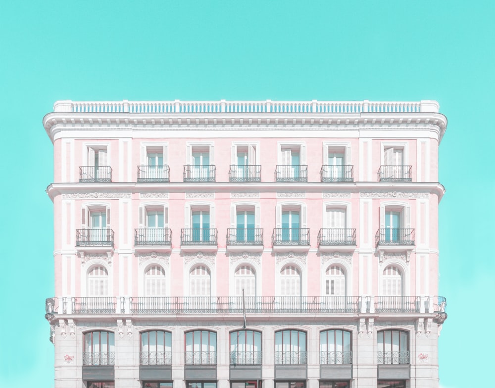 a large pink building with balconies and balconies