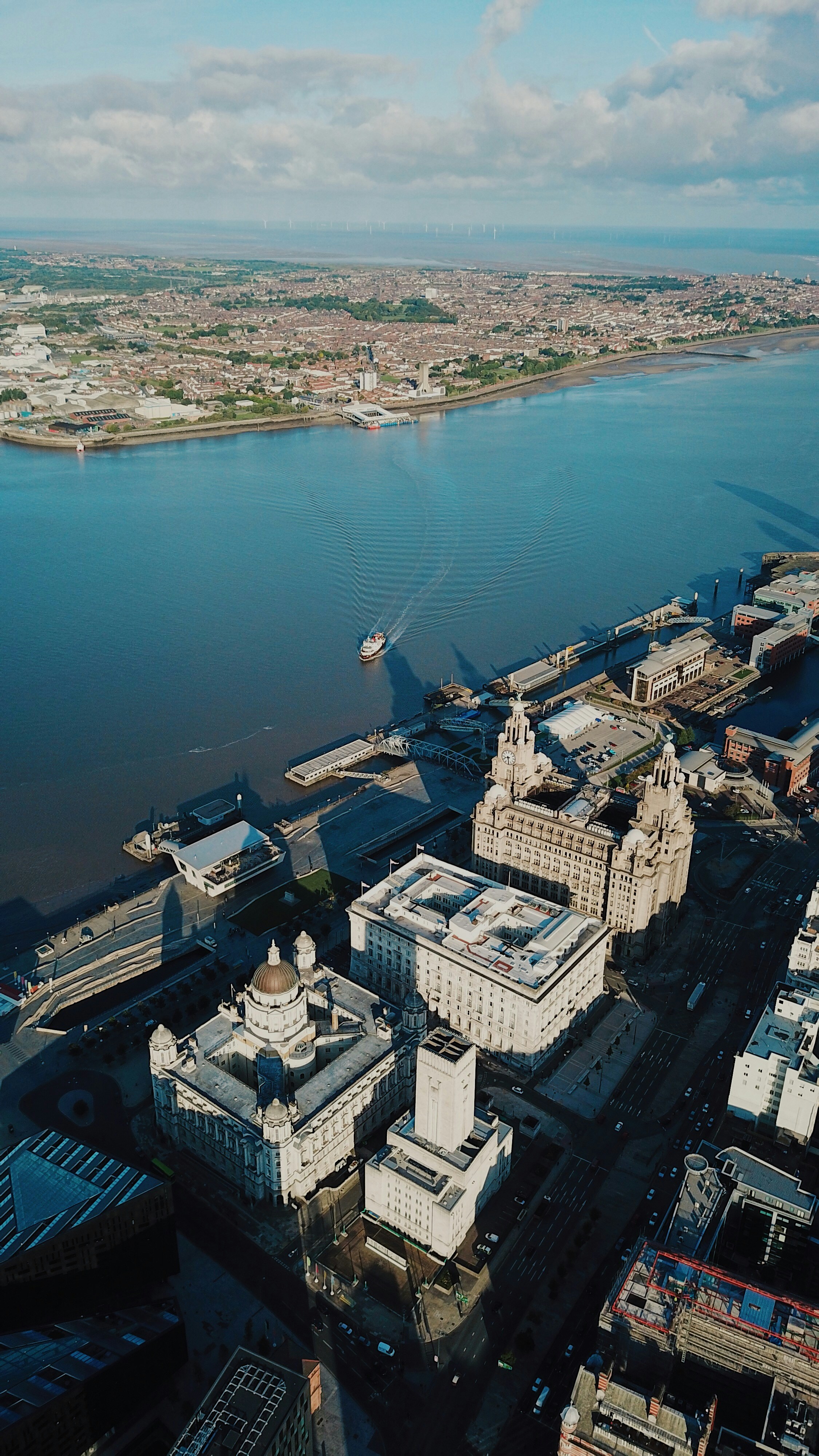 An aerial drone photo showing the River Mersey and a ferry boat crossing it, in the photo you can see both sides of the Mersey which are the city of Liverpool and the Wirral peninsula. Photo taken with a DJI Mavic Pro Drone