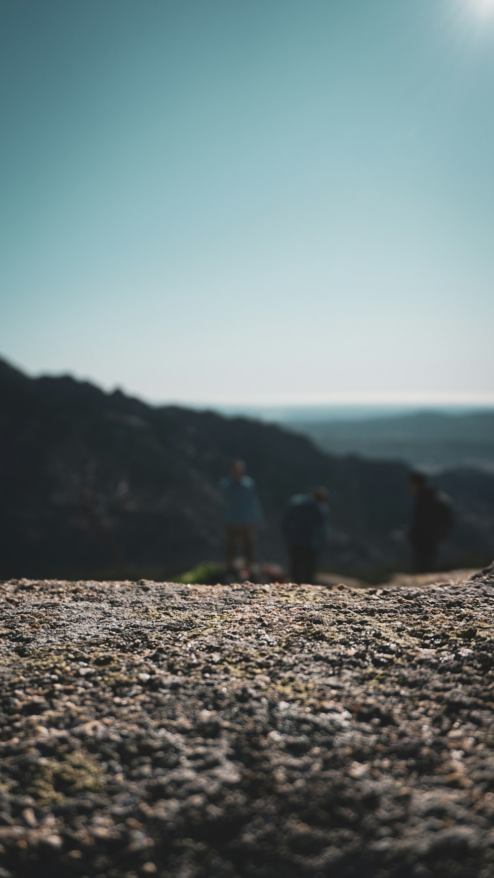 three person standing on the mountain field