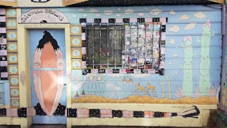 Colorful mural with cacti and natural elements at Giramundo Hostel entrance